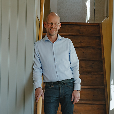 Bild på Fredrik Sandberg i en trappa i butiken Leon Sandbergs Bosättningsaffär